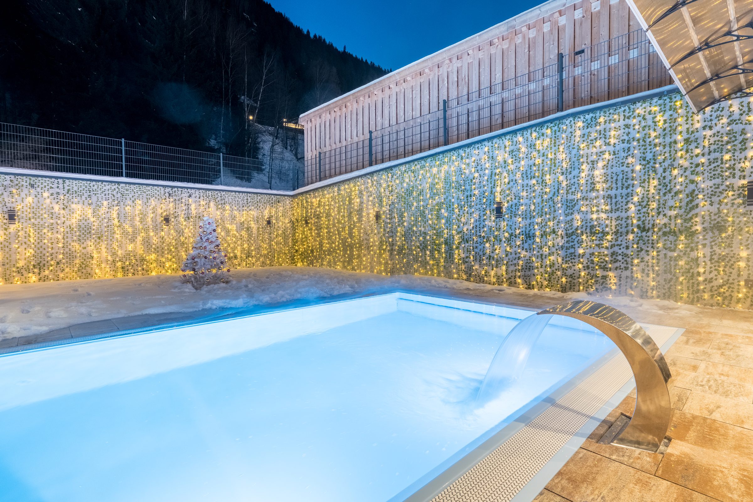 Beheizter Außenpool des Hotel Alpenkönigin bei Nacht, Lichter und Schnee